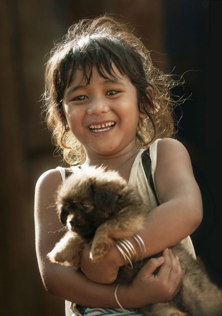 A child hugging a fluffy puppy